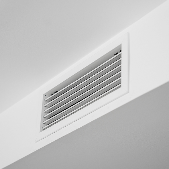 White ventilation grille set into a wall near the ceiling