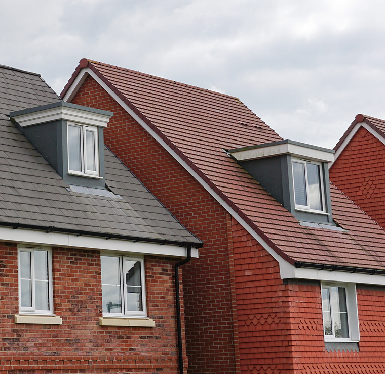 Red brick houses with dormer windows and tiled roofs